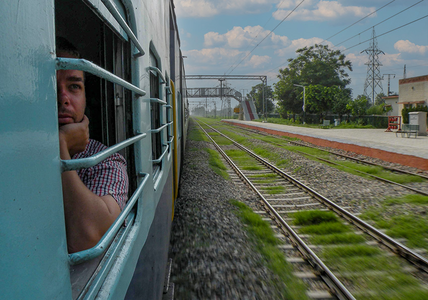 Henric på tåg på elektrifierad bana genom Indien